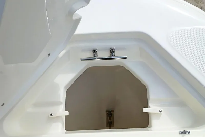 Slide: The Image of 2026 Pioneer 202 Sportfish boat storage compartment with open hatch, showcasing interior space. - 19