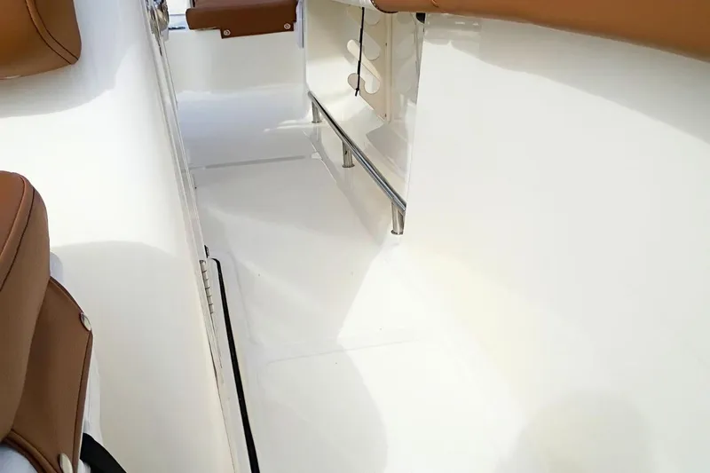 Slide: The Image of Interior view of 2026 Pioneer 202 Sportfish boat, featuring sleek white surfaces and brown seating. - 25