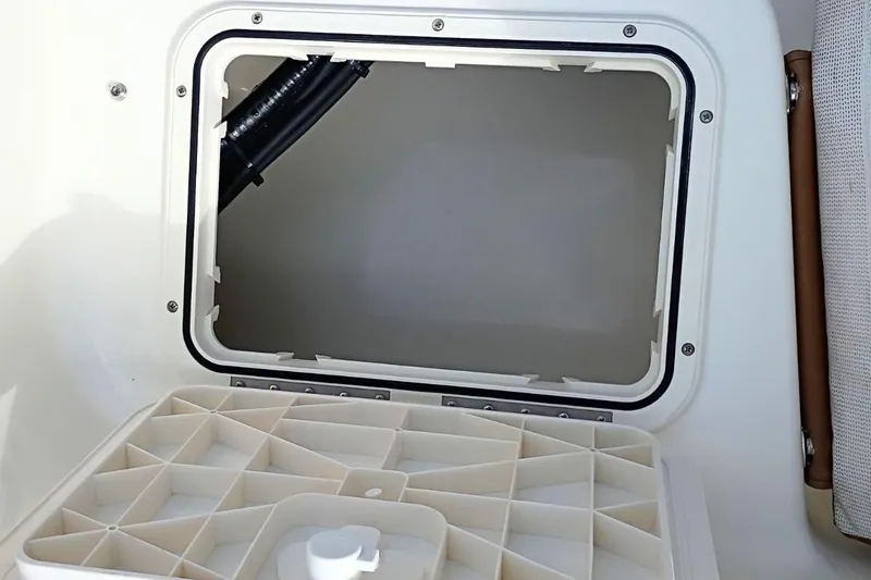 Slide: The Image of 2026 Pioneer 202 Sportfish boat storage compartment with open hatch and organized interior. - 34