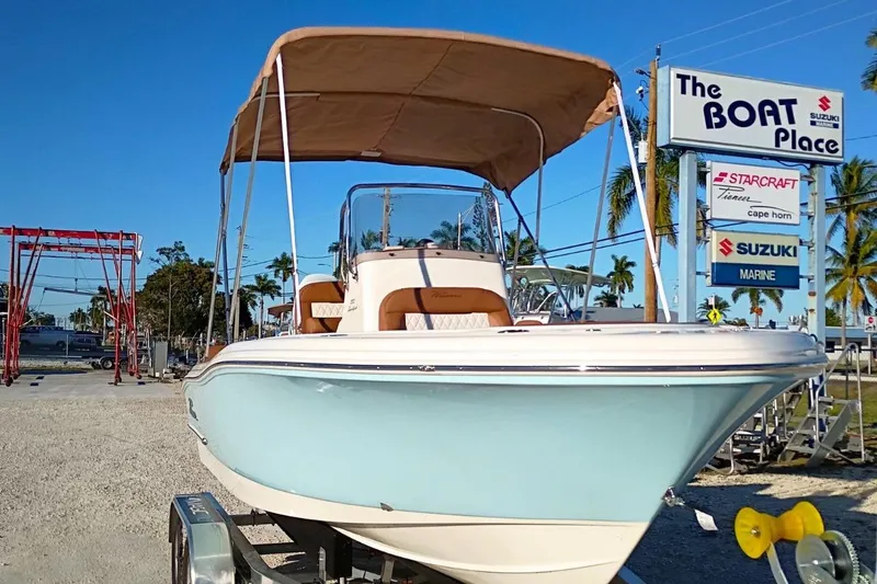 Slide: The Image of 2026 Pioneer 202 Sportfish boat on trailer, sunlit, with palm trees in background. - 5