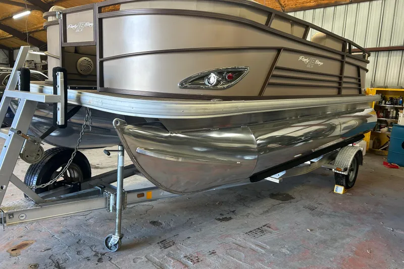 The Image of 2023 Sun Tracker Party Barge 18 DLX on trailer, parked on a sunny road. - 0