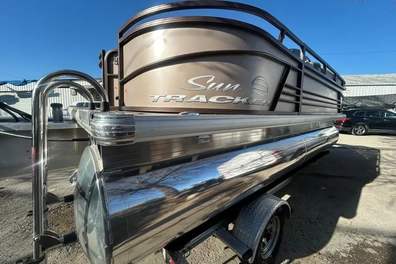 Slide: The Image of 2023 Sun Tracker Party Barge 18 DLX pontoon boat on trailer, parked outdoors. - 3