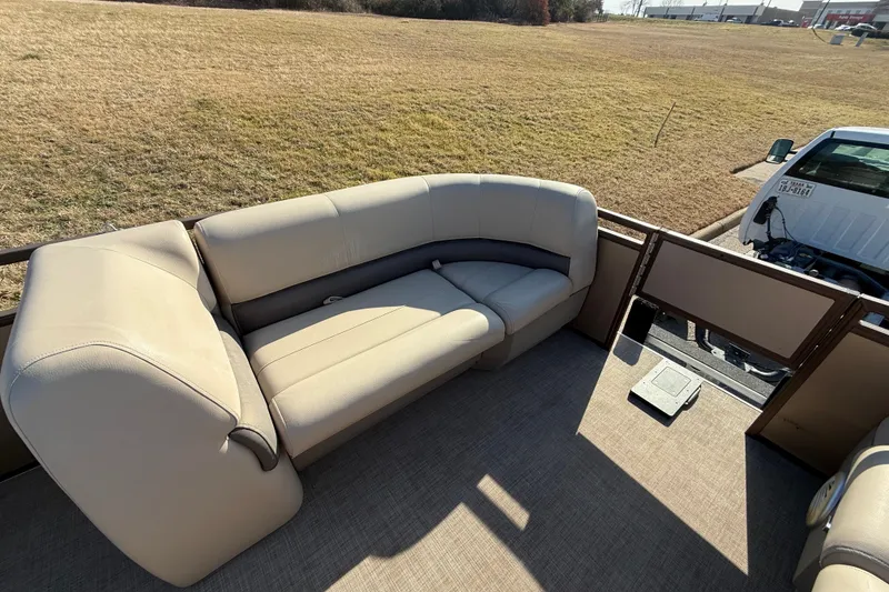 Slide: The Image of 2023 Sun Tracker Party Barge 18 DLX with beige seating, parked on grass. - 34