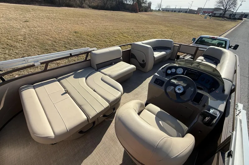 Slide: The Image of 2023 Sun Tracker Party Barge 18 DLX interior with beige seating and steering console. - 43