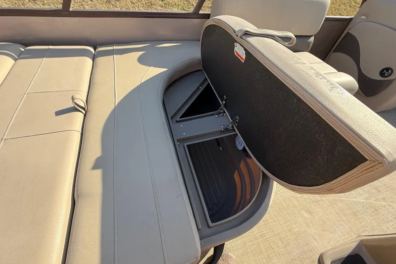 Slide: The Image of 2023 Sun Tracker Party Barge 18 DLX with open storage compartment on beige seating. - 49