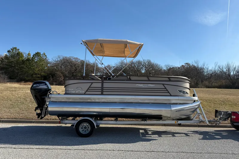 Slide: The Image of 2023 Sun Tracker Party Barge 18 DLX pontoon boat on trailer, parked outdoors. - 58