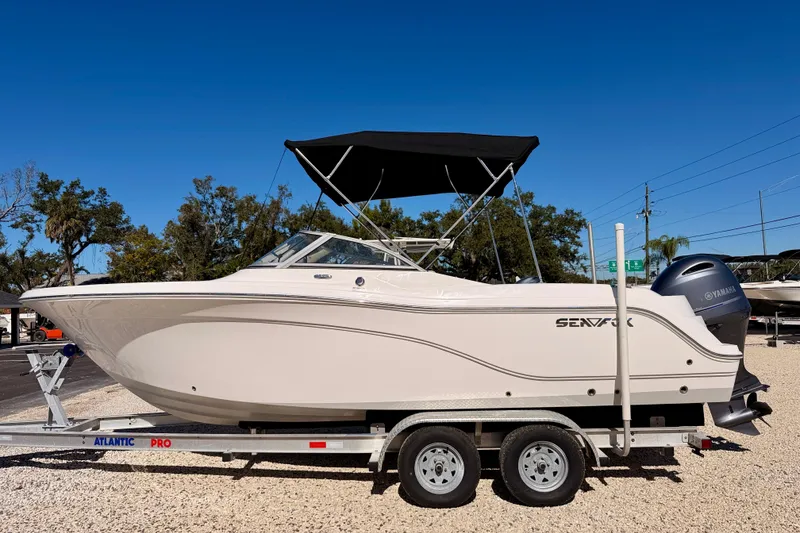 The Image of 2023 Sea Fox 228 Traveler boat on trailer, side view, under clear blue sky. - 0