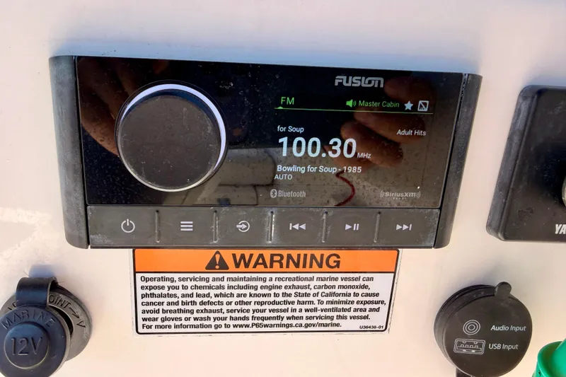 Slide: The Image of Fusion marine stereo on 2023 Sea Fox 228 Traveler boat dashboard with warning label. - 16