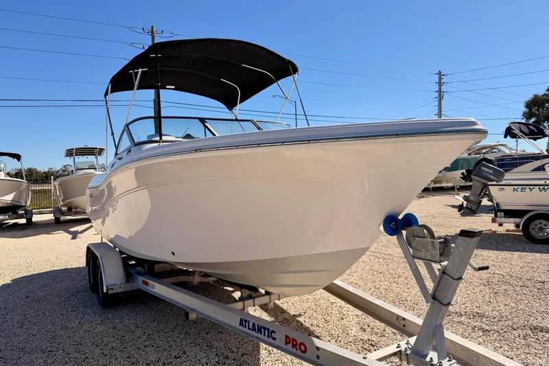 Slide: The Image of 2023 Sea Fox 228 Traveler boat on trailer, featuring sleek design and black canopy. - 2