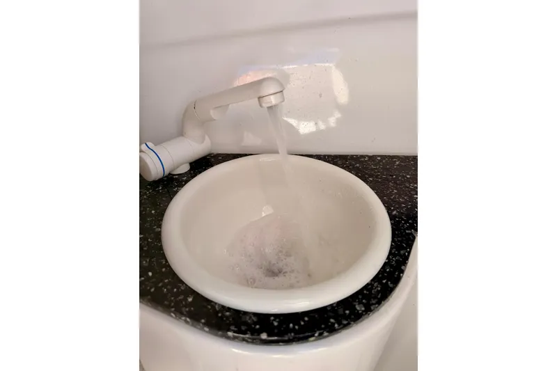 Slide: The Image of 2023 Sea Fox 228 Traveler boat sink with running water, white basin, and black countertop. - 21