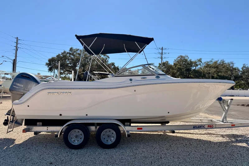 Slide: The Image of 2023 Sea Fox 228 Traveler boat on trailer, featuring Yamaha engine, parked outdoors. - 3