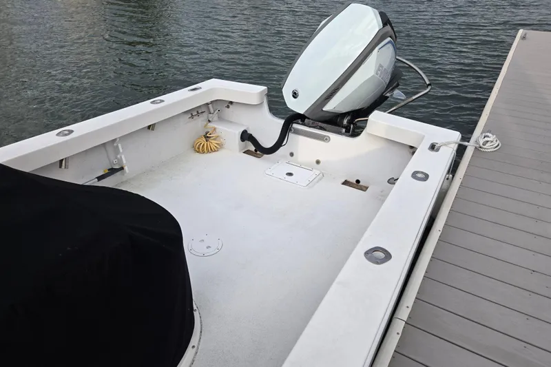 Slide: The Image of 2020 May-Craft 23 Cape Classic boat docked, featuring a clean deck and outboard motor. - 5