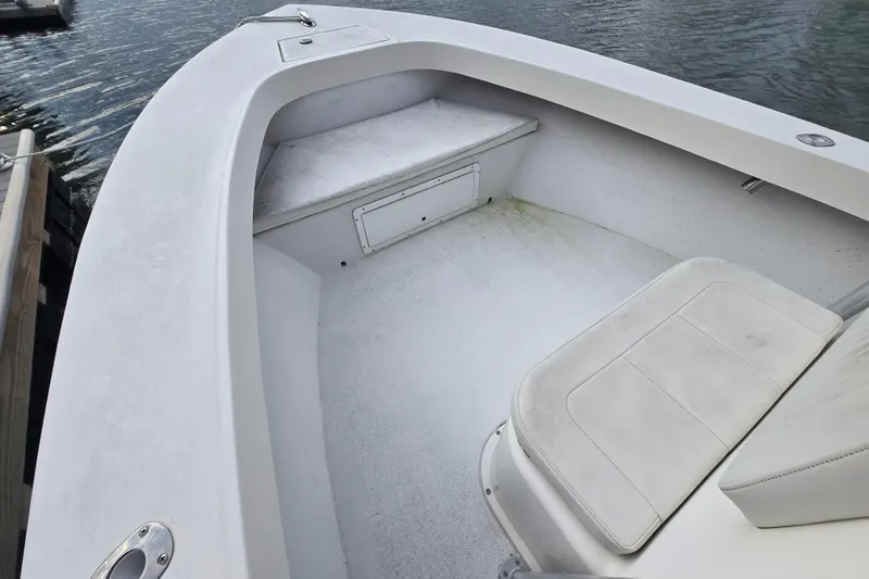 Slide: The Image of 2020 May-Craft 23 Cape Classic boat interior with seating and storage, docked by the water. - 9