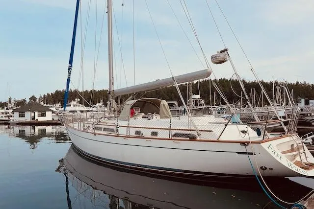 The Image of 2006 Tayana Deck Salon sailboat docked in a marina, reflecting on calm water. - 0