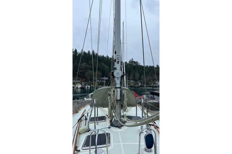 Slide: The Image of 2006 Tayana Cutter sailboat deck view with mast and rigging in a marina setting. - 12