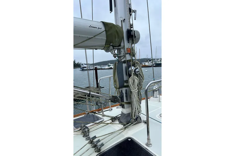 Slide: The Image of 2006 Tayana Cutter sailboat deck with rigging and mast in marina setting. - 16