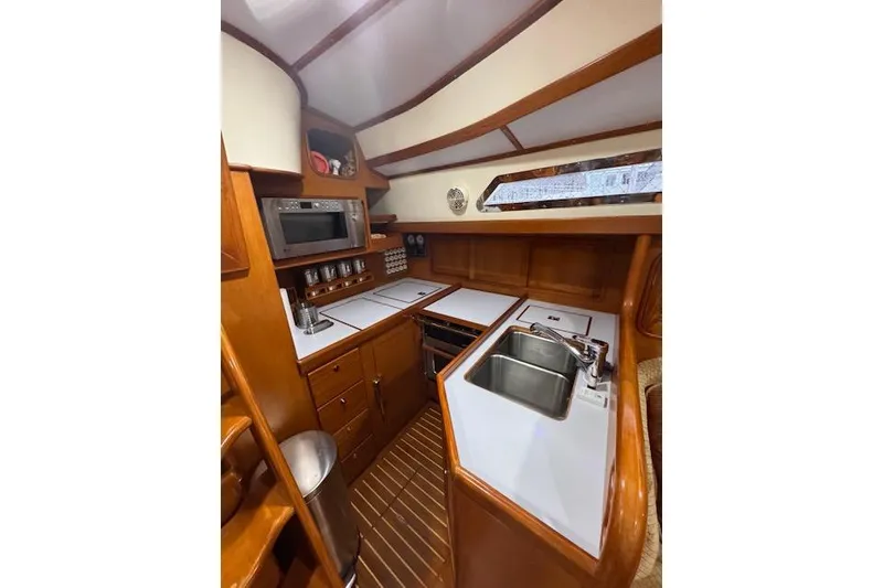 Slide: The Image of 2006 Tayana Deck Salon yacht kitchen with wood cabinetry, sink, and microwave. - 4