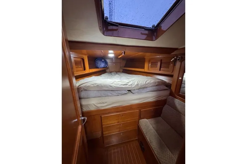 Slide: The Image of 2006 Tayana Deck Salon interior cabin with cozy bed and wooden furnishings. - 6