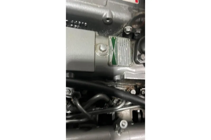 Slide: The Image of Close-up of a 2006 Tayana Cutter engine component with visible label and bolts. - 9