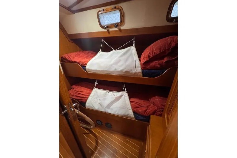 Slide: The Image of Bunk beds in 2006 Tayana Deck Salon yacht cabin with red bedding and wooden interior. - 7