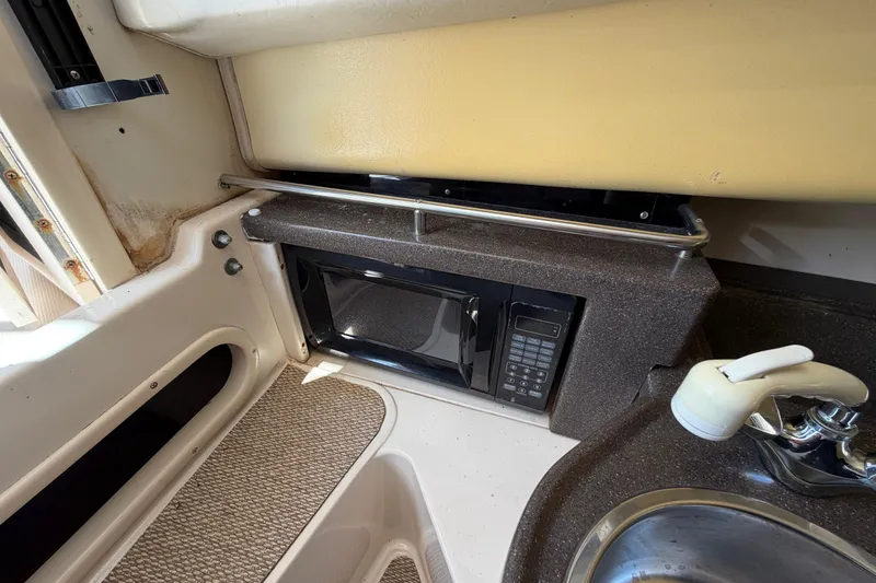 Slide: The Image of 2006 Grady-White Sailfish 282 interior with microwave and sink in compact kitchen area. - 127