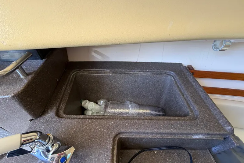 Slide: The Image of 2006 Grady-White Sailfish 282 boat sink with faucet and storage area. - 128