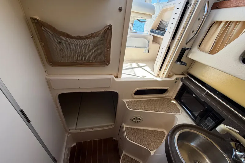 Slide: The Image of 2006 Grady-White Sailfish 282 cabin interior with kitchenette and storage. - 130