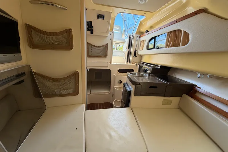 Slide: The Image of 2006 Grady-White Sailfish 282 cabin interior with kitchenette, seating, and storage. - 137