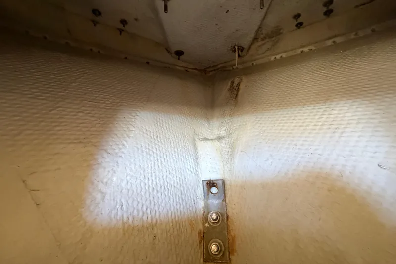 Slide: The Image of Interior view of a 2006 Grady-White Sailfish 282 boat, showing textured walls and metal fittings. - 138