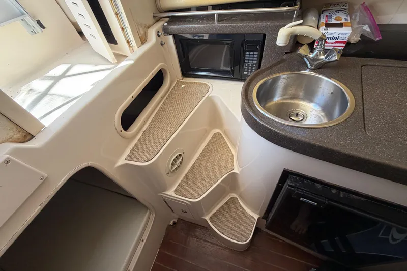 Slide: The Image of 2006 Grady-White Sailfish 282 interior with sink, microwave, and carpeted steps. - 146