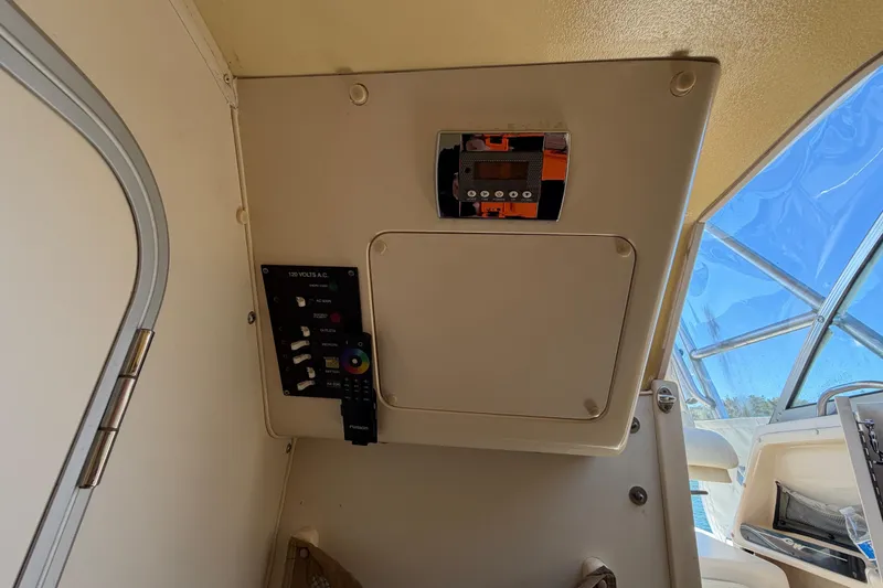 Slide: The Image of 2006 Grady-White Sailfish 282 cabin interior with control panel and window view. - 147