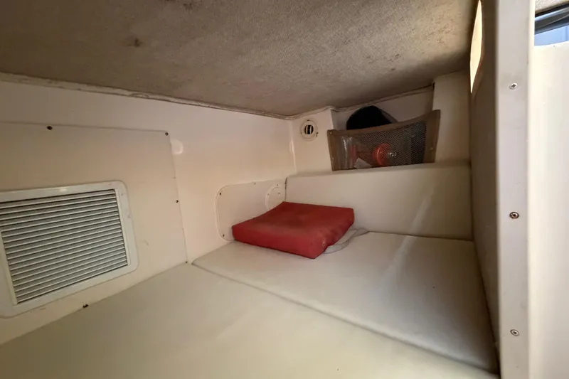 Slide: The Image of 2006 Grady-White Sailfish 282 cabin interior with cushion and storage compartment. - 148