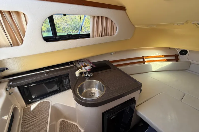 Slide: The Image of 2006 Grady-White Sailfish 282 cabin interior with kitchenette, sink, and seating area. - 163