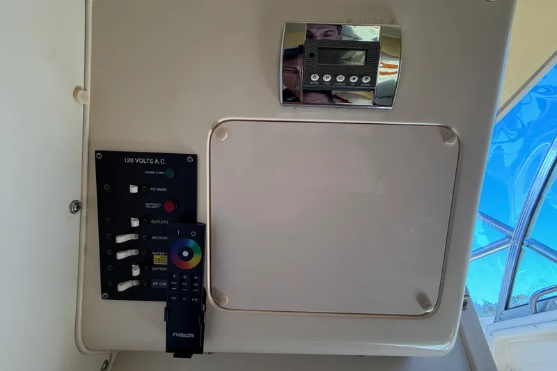 Slide: The Image of Control panel on 2006 Grady-White Sailfish 282 boat, featuring switches and a remote. - 165