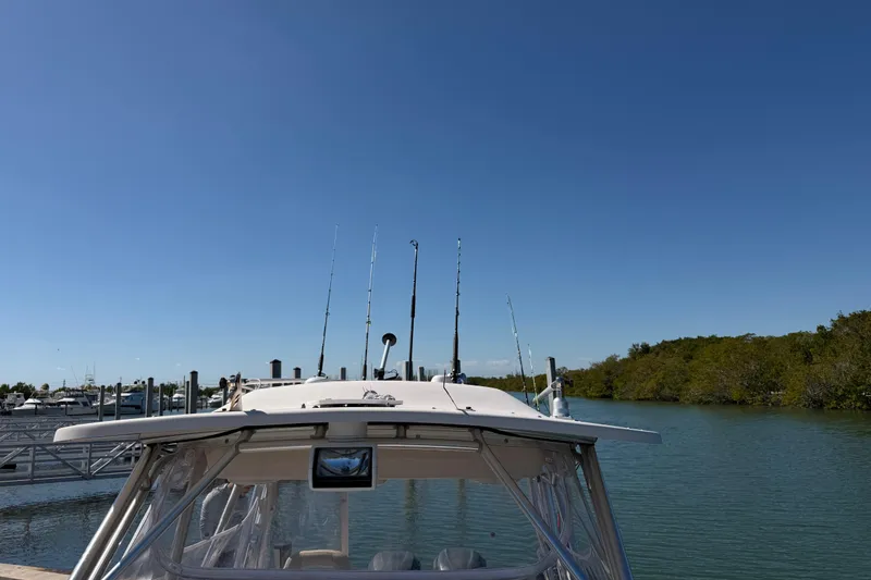 Slide: The Image of 2006 Grady-White Sailfish 282 boat docked by a serene waterfront under clear blue skies. - 169