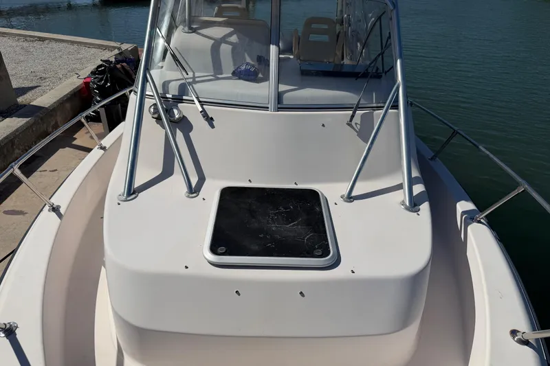 Slide: The Image of 2006 Grady-White Sailfish 282 boat deck with windshield and railing, docked by water. - 175