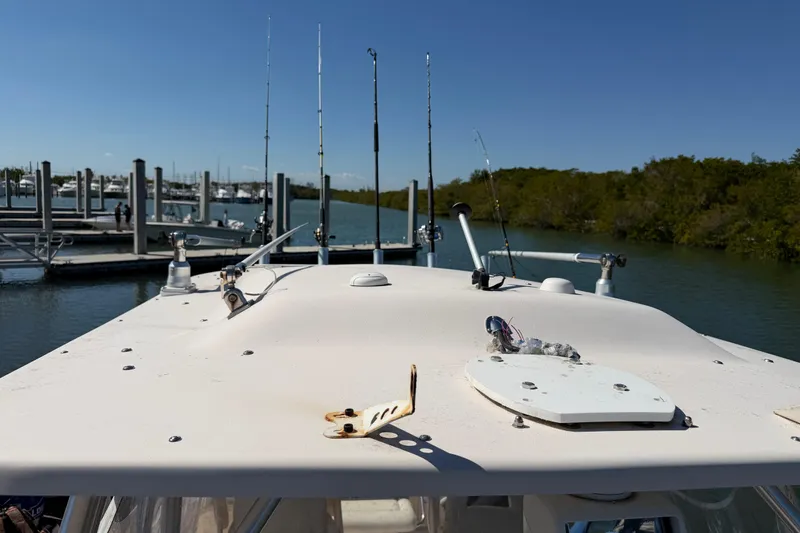 Slide: The Image of 2006 Grady-White Sailfish 282 boat docked, featuring fishing rods and calm marina backdrop. - 181