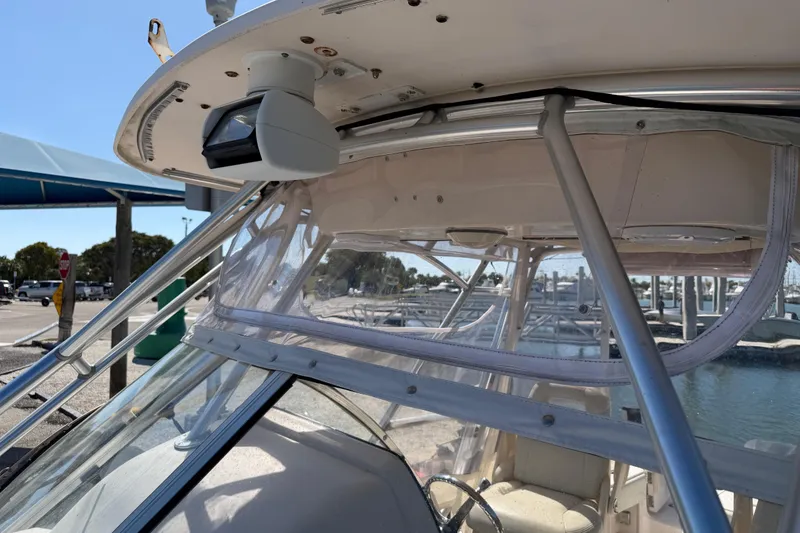 Slide: The Image of 2006 Grady-White Sailfish 282 boat with clear canopy and marina background. - 184