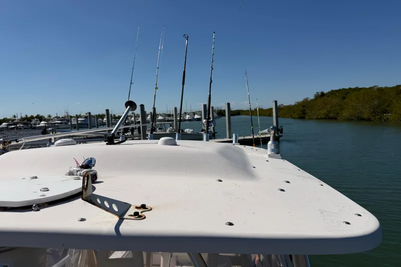 Slide: The Image of 2006 Grady-White Sailfish 282 boat with fishing rods docked by the water. - 186