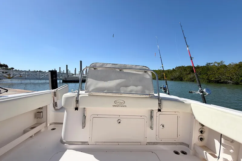 Slide: The Image of 2006 Grady-White Sailfish 282 boat with fishing rods, docked by a serene waterfront. - 201
