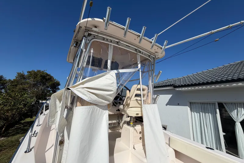 Slide: The Image of 2006 Grady-White Sailfish 282 boat with canopy and seating, parked near a house. - 37