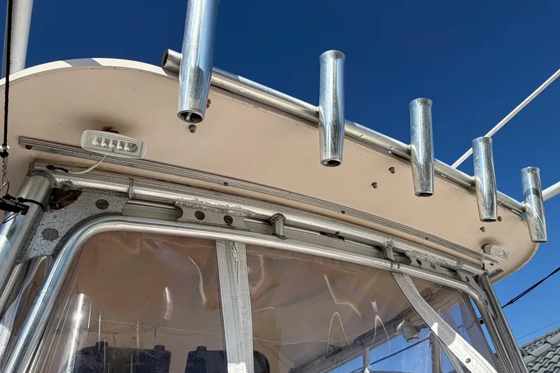 Slide: The Image of 2006 Grady-White Sailfish 282 boat with rod holders and clear canopy under blue sky. - 39
