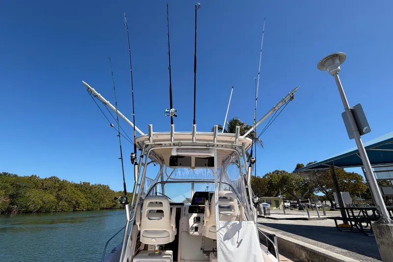 Slide: The Image of 2006 Grady-White Sailfish 282 boat with fishing rods, docked under clear blue sky. - 75