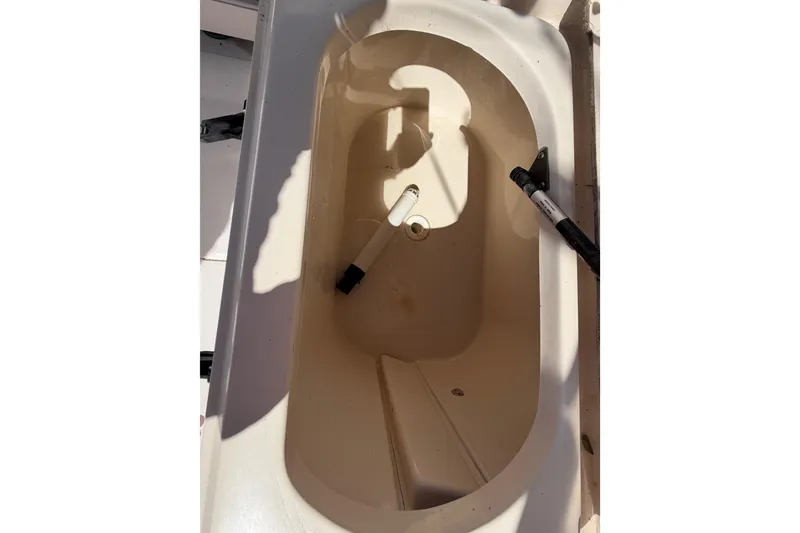 Slide: The Image of 2006 Grady-White Sailfish 282 boat compartment, open and empty, with visible handles. - 85