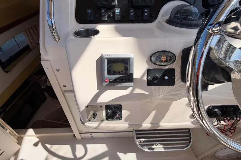 Slide: The Image of 2006 Grady-White Sailfish 282 boat dashboard with navigation controls and steering wheel. - 96