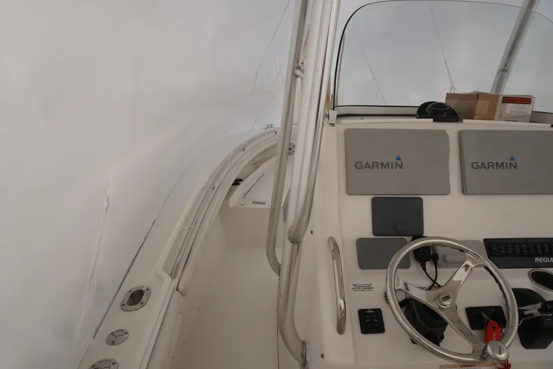 Slide: The Image of 2018 Regulator 23 boat interior with Garmin navigation system and steering wheel. - 16