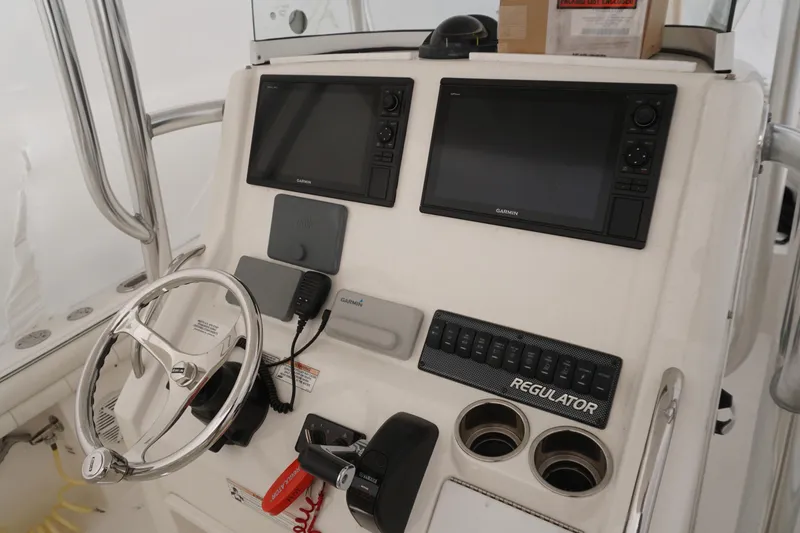 Slide: The Image of 2018 Regulator 23 boat dashboard with Garmin displays and steering wheel. - 4
