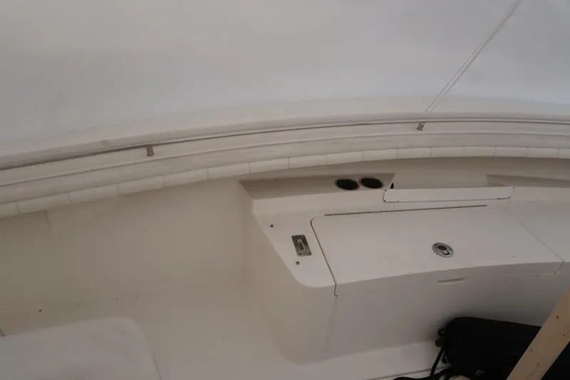 Slide: The Image of 2018 Regulator 23 boat interior with storage compartment and cup holders. - 7
