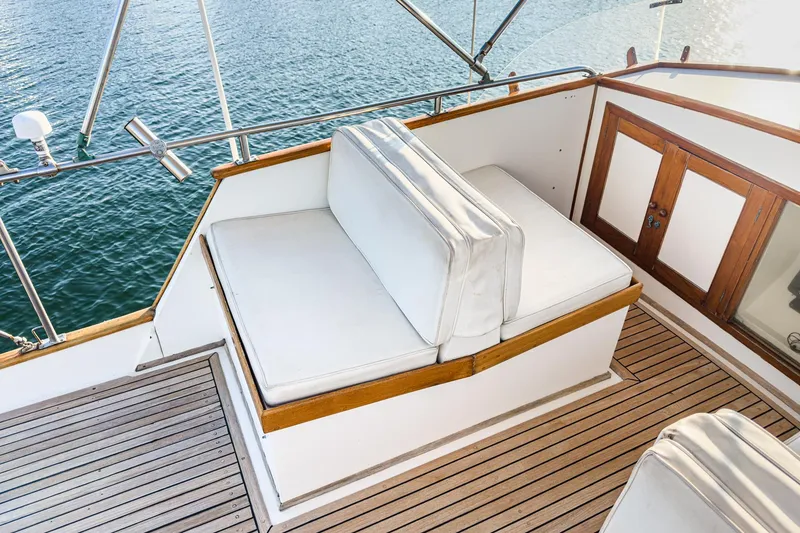 Slide: The Image of 1984 Grand Banks 42 Classic yacht with white cushioned seating and wooden deck. - 13