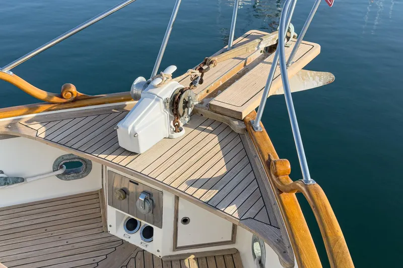 Slide: The Image of 1984 Grand Banks 42 Classic yacht deck with wooden finish and anchor equipment. - 21